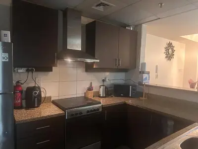 a kitchen with black cabinets and a stove top oven at Luxury furnished bed room for VIP family in Dubai