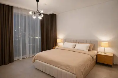 a bedroom with a bed and a large window at Stylish Brand New 2 bed Stay near Marina in Dubai