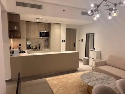 a kitchen and a living room with a couch and a table at Stylish Brand New 2 bed Stay near Marina in Dubai