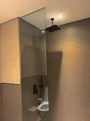a bathroom with a toilet in a shower stall at Stylish Brand New 2 bed Stay near Marina in Dubai