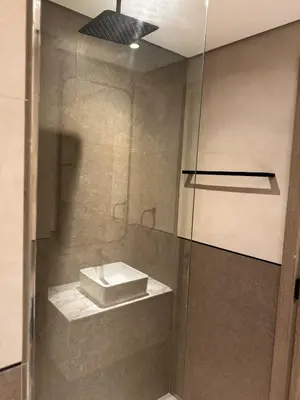 a bathroom with a shower with a sink at Stylish Brand New 2 bed Stay near Marina in Dubai