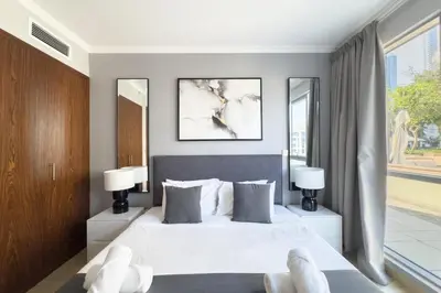 a bedroom with a large white bed with two lamps at Burj Khalifa & Fountain View - Downtown - 2BR in Dubai