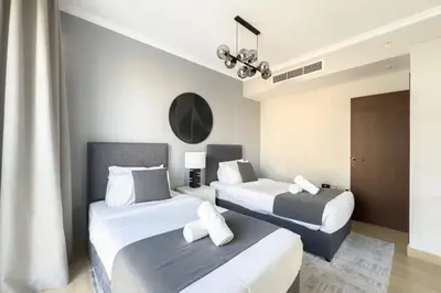 two beds in a hotel room with white and gray at Burj Khalifa & Fountain View - Downtown - 2BR in Dubai
