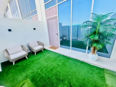 a living room with green grass and a palm tree at Modern brand new Loft Townhouse in Dubai in Dubai