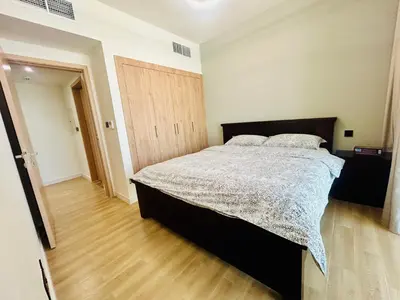 a bedroom with a bed and a wooden floor at Modern brand new Loft Townhouse in Dubai in Dubai