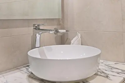 a white bath tub sitting on a counter in a bathroom at DAMAC Aykon Tower - High-Floor Luxury 2-Bedroom Apartment in Dubai