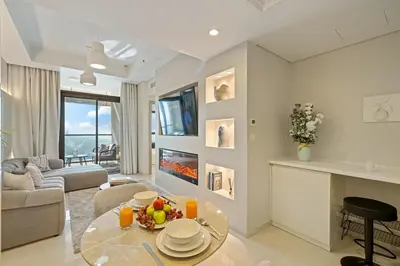 a living room with a glass table and a fireplace at DAMAC Aykon Tower - High-Floor Luxury 2-Bedroom Apartment in Dubai
