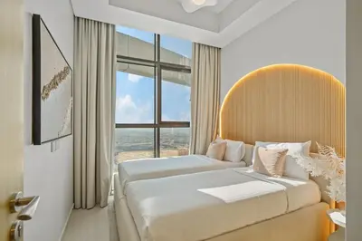 two beds in a room with a large window at DAMAC Aykon Tower - High-Floor Luxury 2-Bedroom Apartment in Dubai