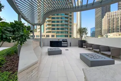 a patio with chairs and tables on top of a building at 3B in Downtown with Burj Khalifa View Near Dubai Mall and Opera District in Dubai