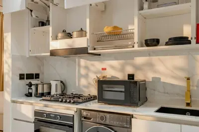 a kitchen with a stove and a microwave at Modern Studio Apartment in Binghatti Tulip with Pool, Parking, Gym in Dubai