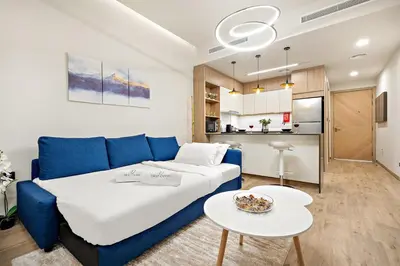 a living room with a blue couch and a table at FIRST CLASS Studio Charming Cozy Comfort in Dubai
