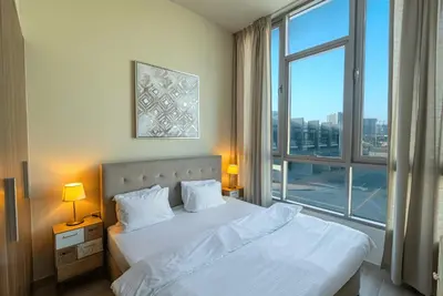 a bedroom with a white bed with a large window at Executive 4BR Townhouse - Al Furjan in Dubai