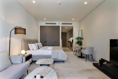 a hotel room with a bed and a living room at Elegant Studio with Iconic Burj Khalifa Views in Dubai