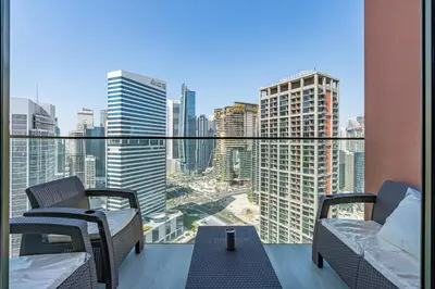 a balcony with two chairs and a view of a city at Elegant Studio with Iconic Burj Khalifa Views in Dubai