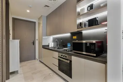a kitchen with a counter with a microwave and a stove at Elegant Studio with Iconic Burj Khalifa Views in Dubai