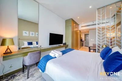 a bedroom with a large bed and a television at Sleek Studio in Privé with Stunning Canal View in Dubai