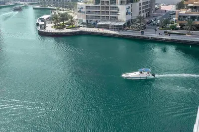 a boat in the water near a city at Marina | Canal View Studio in Cayan Tower in Dubai