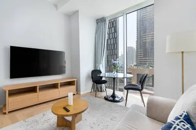 a living room with a television and a table with chairs at Marina | Canal View Studio in Cayan Tower in Dubai