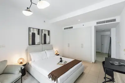 a white bedroom with a bed and a couch at Modern Comfort - Convenient - Prime JLT Living in Dubai