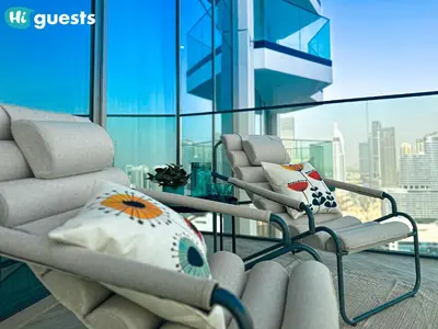 a living room with two chairs and a large window at HiGuests - Peninsula Luxury 1 BR with Stunning Water Views in Dubai