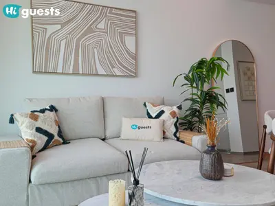 a living room with a couch and a table at HiGuests - Peninsula Luxury 1 BR with Stunning Water Views in Dubai