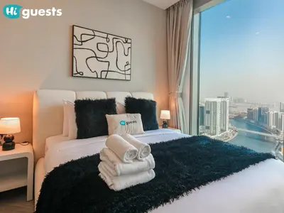 a hotel room with a bed with towels on it at HiGuests - Peninsula Luxury 1 BR with Stunning Water Views in Dubai