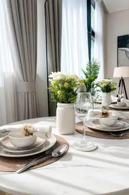 a white table with plates and glasses and flowers on it at Luxury 1BR W Private Pool Binghatti Royale in Dubai