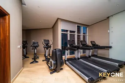 a gym with treadmills and ellipticals in a room at Elegant Studio Living in Privé in Dubai