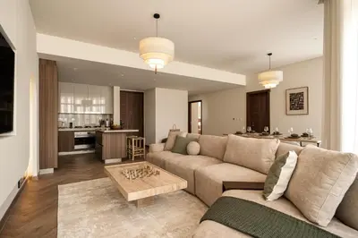 a living room with a couch and a kitchen at Seraya Residences at Imperial Avenue Dubai in Dubai