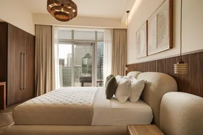 a bedroom with a bed and a large window at Seraya Residences at Imperial Avenue Dubai in Dubai