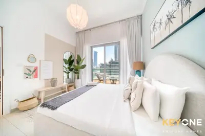 a white bedroom with a large bed and a window at Modern One Bedroom with Stylish Touches in Dubai