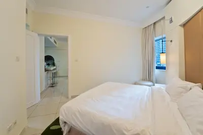 a bedroom with a white bed and a bathroom at Next to Dubai Mall & Burj Khalifa I Luxury Design in Dubai