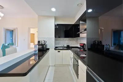 a kitchen with black and white counter tops at Next to Dubai Mall & Burj Khalifa I Luxury Design in Dubai