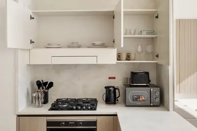 a kitchen with a stove and a microwave at Elevated 1BR with Private Pool at Binghatti Phantom in Dubai