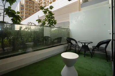 a balcony with chairs and a table and grass at Escape24 Luxury Studio 100