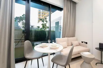 a living room with a white couch and a table and chairs at Escape24 Luxury Studio 100