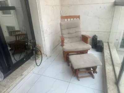 a chair and a stool sitting on a porch at Twin tower in Dubai