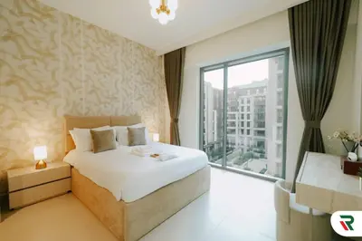 a bedroom with a large bed and a large window at 2BR Apartment With Lagoon Access In Creek Harbour in Dubai