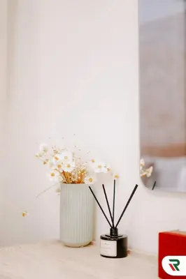 a white vase with white flowers sitting on a table at 2BR Apartment With Lagoon Access In Creek Harbour in Dubai