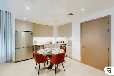 a kitchen with a table and chairs in a room at 2BR Apartment With Lagoon Access In Creek Harbour in Dubai