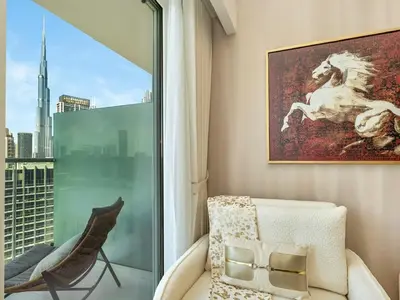 a room with a window and a chair and a painting at Chic 1BR With Burj Views And Near Dubai Mall in Dubai