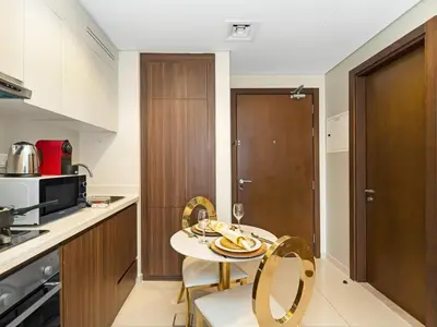 a kitchen with a small table and chairs in a kitchen at Chic 1BR With Burj Views And Near Dubai Mall in Dubai