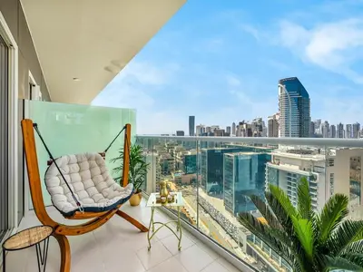 a swinging chair on a balcony with a view of the city at Chic 1BR With Burj Views And Near Dubai Mall in Dubai