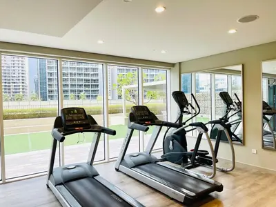 a gym with three elliptical machines in a room with windows at Chic 1BR With Burj Views And Near Dubai Mall in Dubai