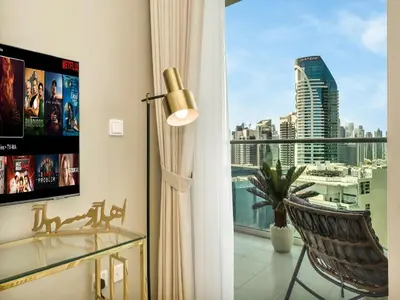 a room with a window with a chair and a view at Chic 1BR With Burj Views And Near Dubai Mall in Dubai