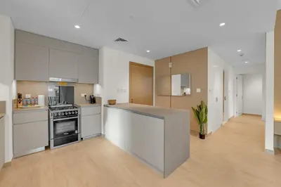 a large kitchen with white cabinets and a counter top at Creek Beach Getaway Lagoon, Pool & Gym Access in Dubai