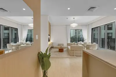 a living room with white furniture and windows at Creek Beach Getaway Lagoon, Pool & Gym Access in Dubai