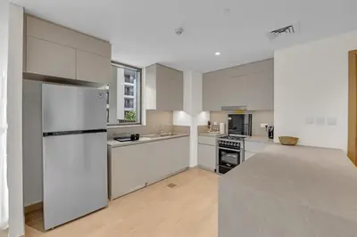 a large kitchen with white cabinets and appliances at Creek Beach Getaway Lagoon, Pool & Gym Access in Dubai