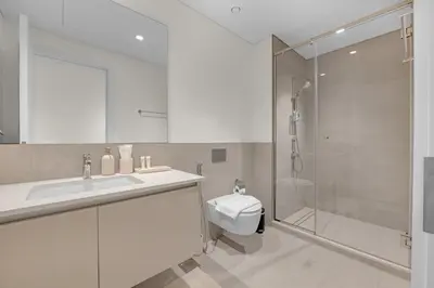 a bathroom with a sink and a shower and a toilet at Creek Beach Getaway Lagoon, Pool & Gym Access in Dubai