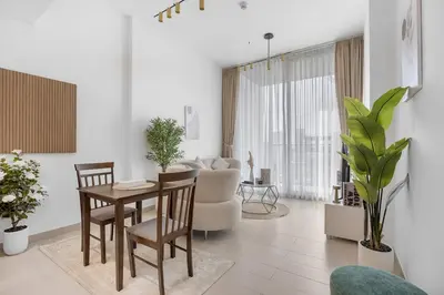 a living room with a table and chairs and a couch at Luxurious JVC Getaway Infinity Pool & Gym in Dubai